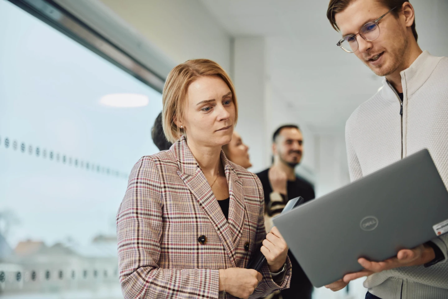 Två kollegor tittar på en laptop tillsammans.