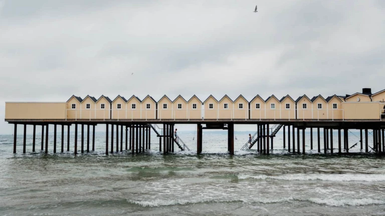 Det klassiska kallbadhuset i Helsingborg sträcker sig ut över vågorna med sina gula träbyggnader på höga pelare.