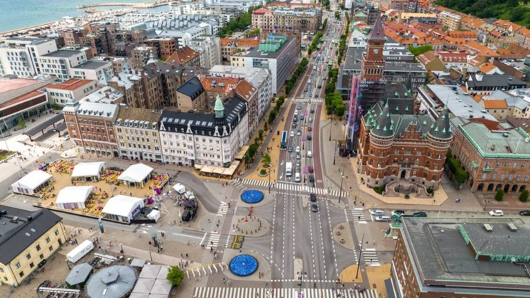 En livlig stadsvy över Helsingborgs centrum med Kärnan, strandpromenaden och Öresund i bakgrunden.