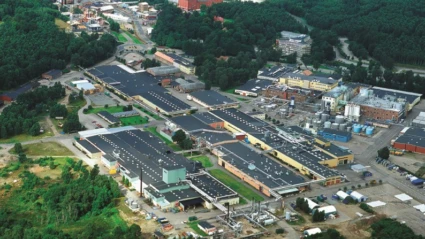 Flygvy över Perstorps industriområde där flera fabriksbyggnader och produktionsanläggningar syns omgivna av tät grönska.