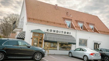 Det klassiska Nisses Konditori i Ängelholm med randig markis, vit fasad och besökare som stannar till för fika.