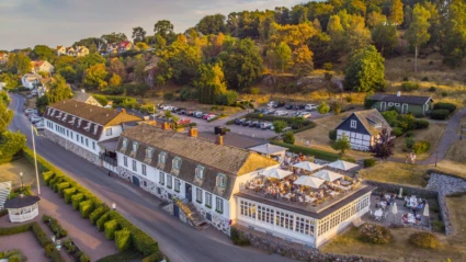Rusthållargården i Arild – en historisk hotell- och restaurangbyggnad med utsikt över havet och omgivande natur.