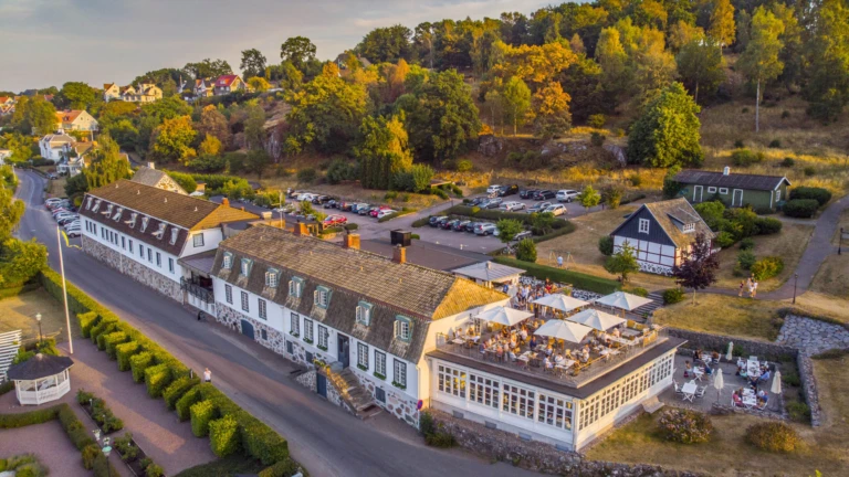 Rusthållargården i Arild – en historisk hotell- och restaurangbyggnad med utsikt över havet och omgivande natur.