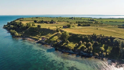 Den idylliska ön Ven ligger omgiven av Öresunds blå vatten, med böljande fält och gårdar i sommarsol.