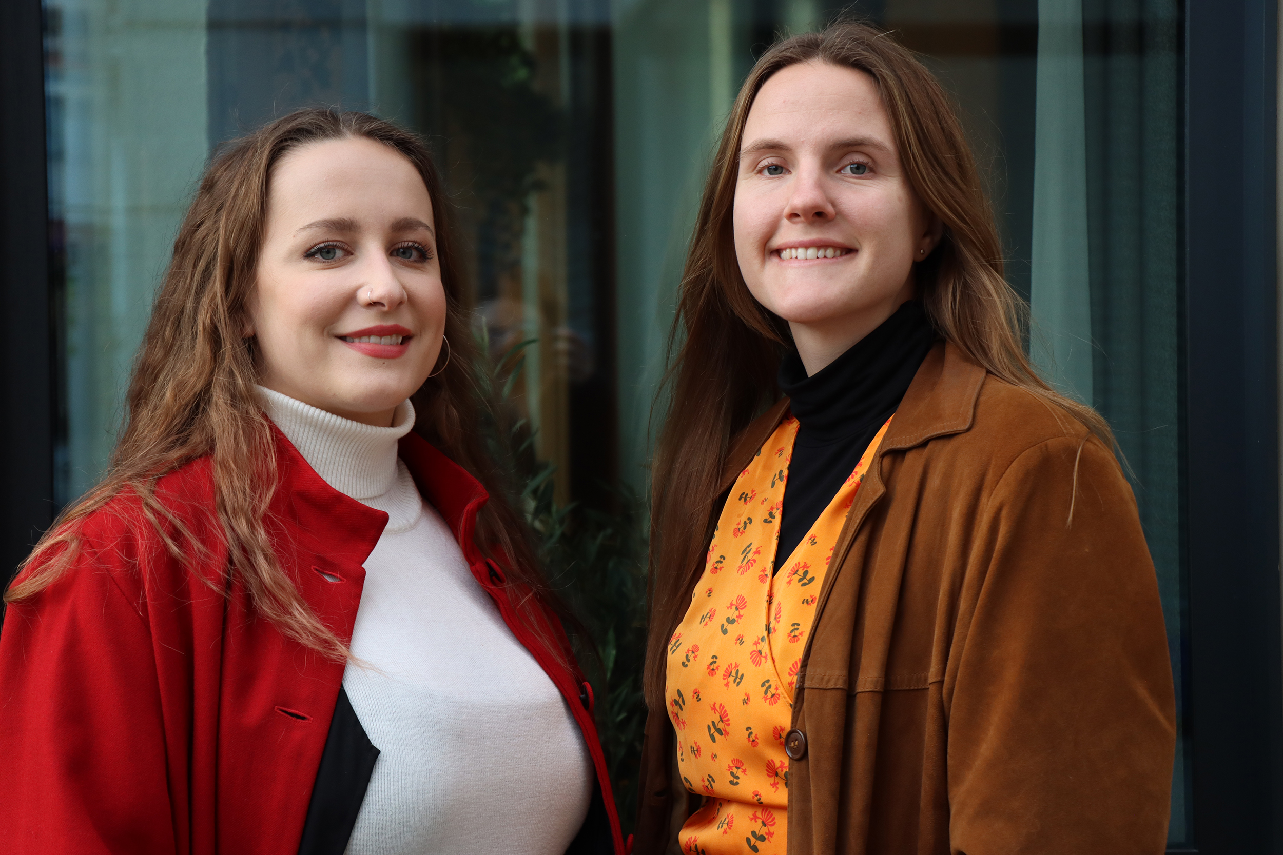 Två tjejer tittandes in i kameran och ler.