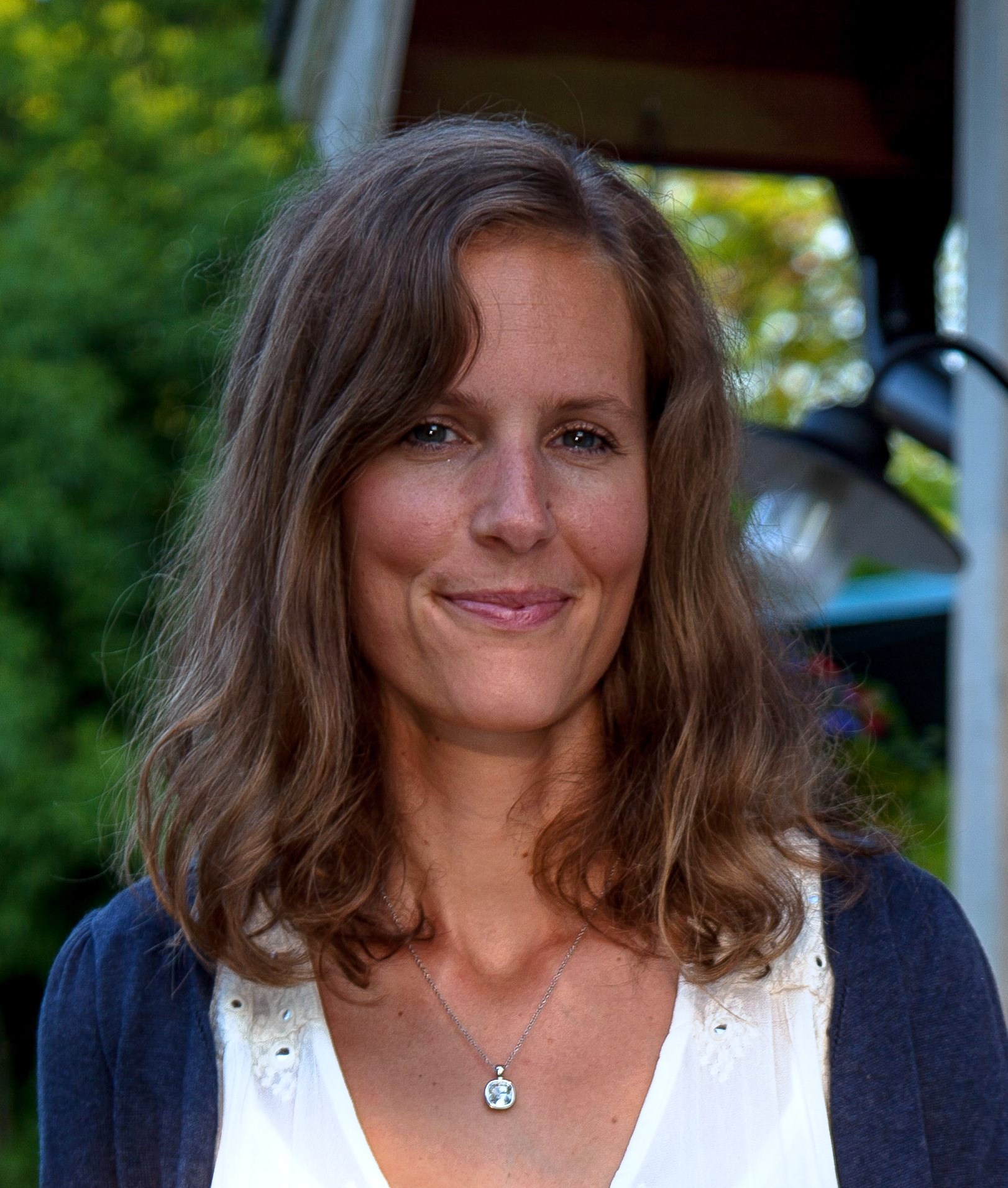 Mörkhårig kvinna som tittar in i kameran.