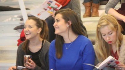 Deltagare sitter i trappan och följer programmet, två skrattar åt något som sagts.