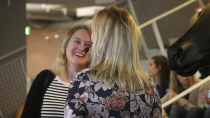 Informellt samtal mellan talare och deltagare i pausen, med publik i bakgrunden.