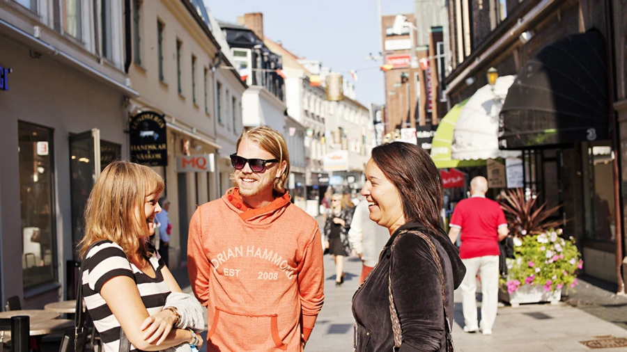 Två kvinnor och en man umgås på Kullagatan i Helsingborg.