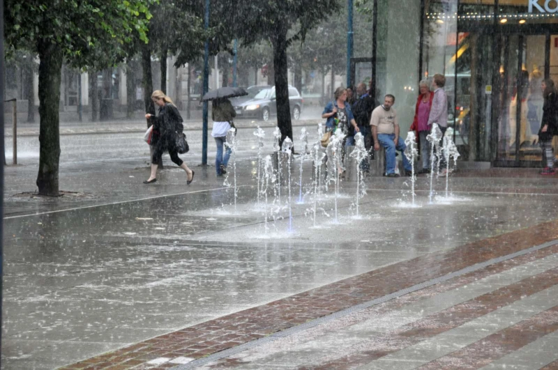 Folk skyddar sig mot regnet under taket utanför Kappahl på Rådhustorget sommaren 2012.