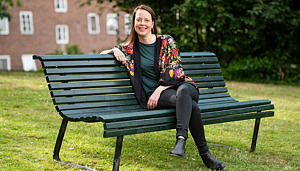 Socialdirektör Emelie Erixon sitter på en bänk och ser glad ut.