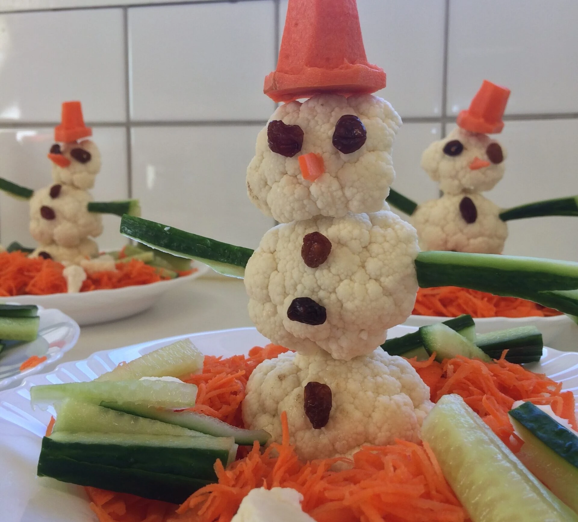 gubbar gjorda av blomkål, morot och gurka