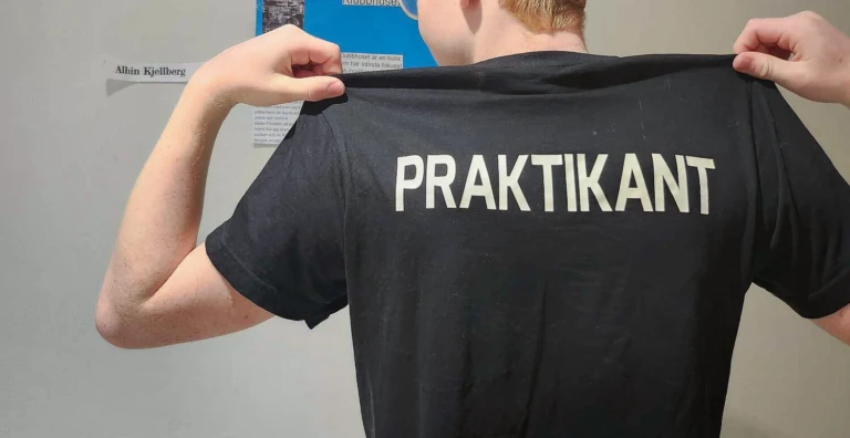 ungdom med texten "praktikant" tryckt på ryggen på sin t-shirt