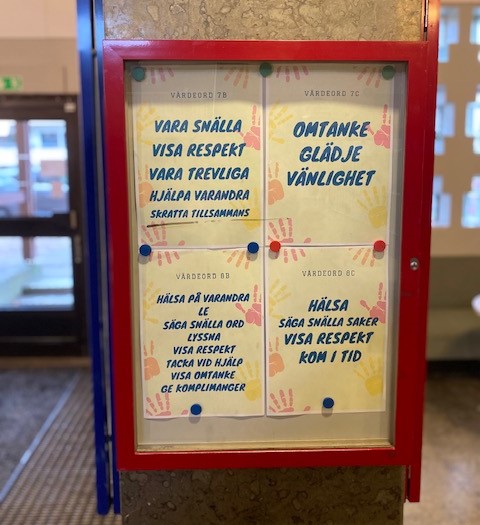 Foto av detalj i skolans miljö som visar inspirerande ord."Omtanke, glädje, vänlighet." "Hälsa på varandra, le, säg snälla ord, lyssna, visa respekt, tacka vid hjälp, visa omtanke, ge komplimanger."