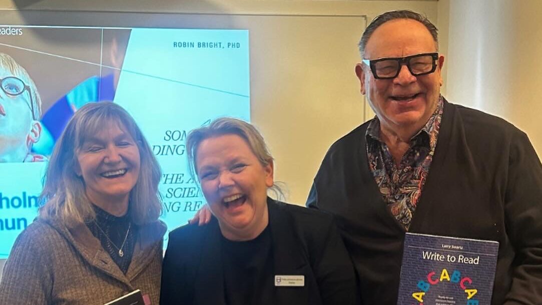 Tre personer står bredvid varandra och skrattar. Föreläsare och rektor.