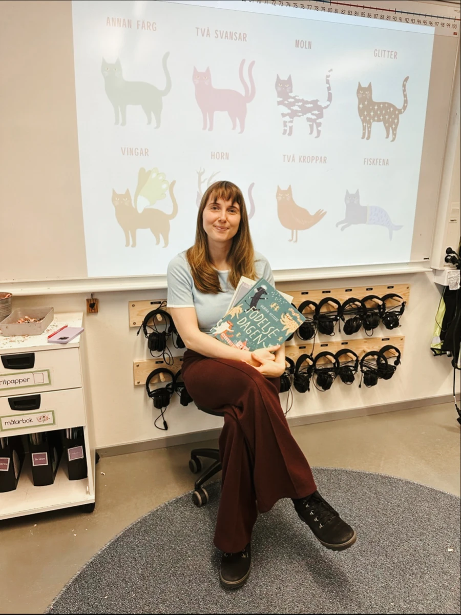 Författaren Ulrika med sina böcker i händerna, på Tågaborgsskolan