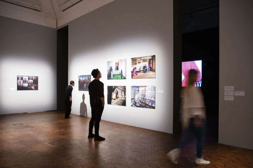 En person tittar på en fotoutställning inne på Dunkers Kulturhus.