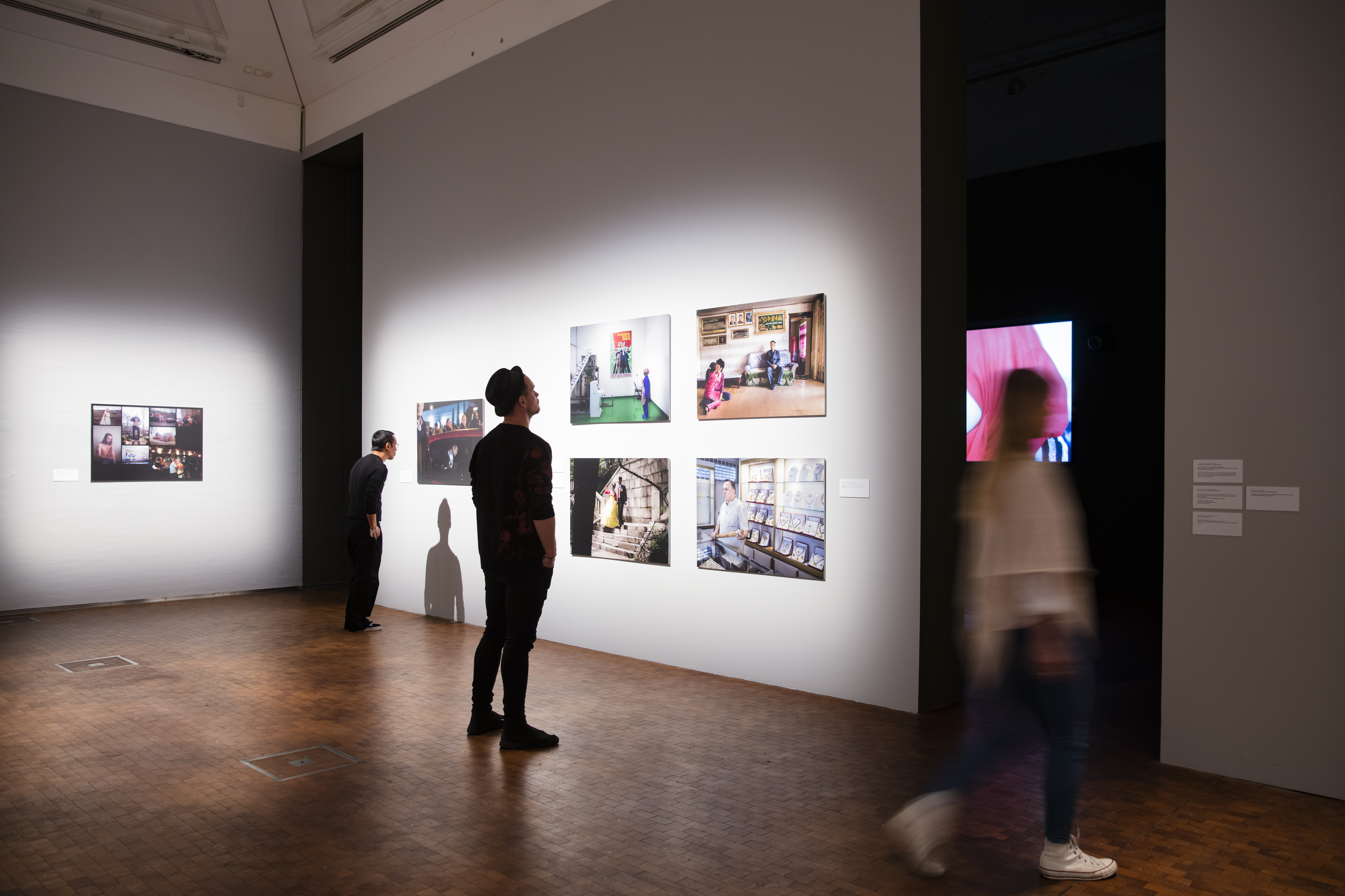En person tittar på en fotoutställning inne på Dunkers Kulturhus.