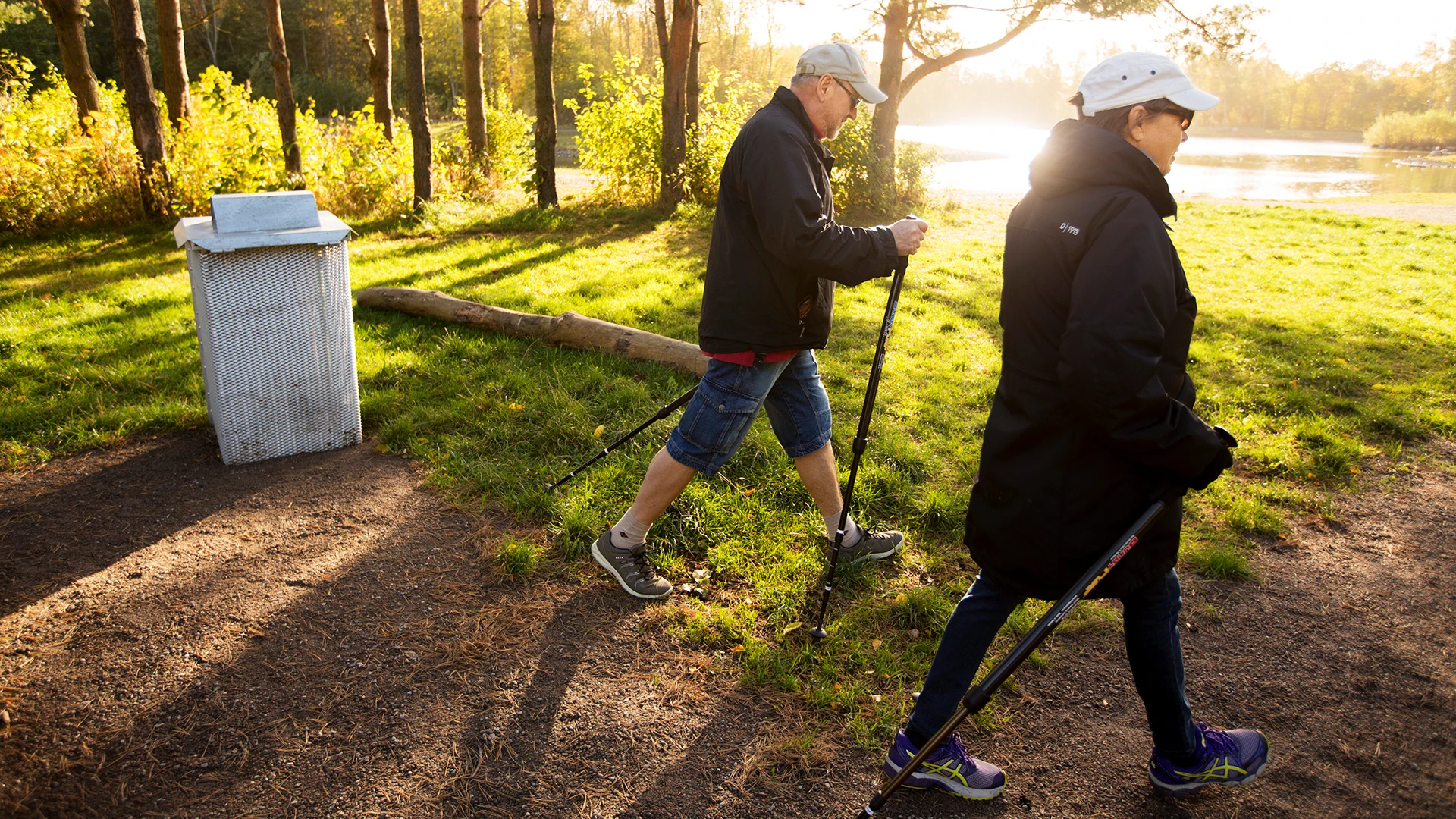Man och kvinna på stavpromenad i naturområde i Helsingborg