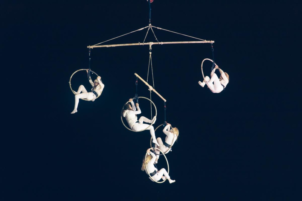 Bilden visar fem akrobater som hänger i ringar i luften