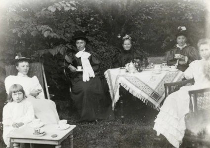 Svartvitt foto från 1894 som visar en samling kvinnor vid kaffebordet i trädgården.