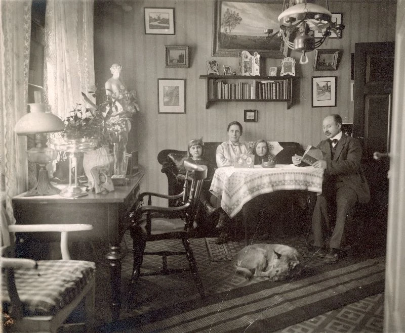 Svartvitt familjefoto i vardagsrum.