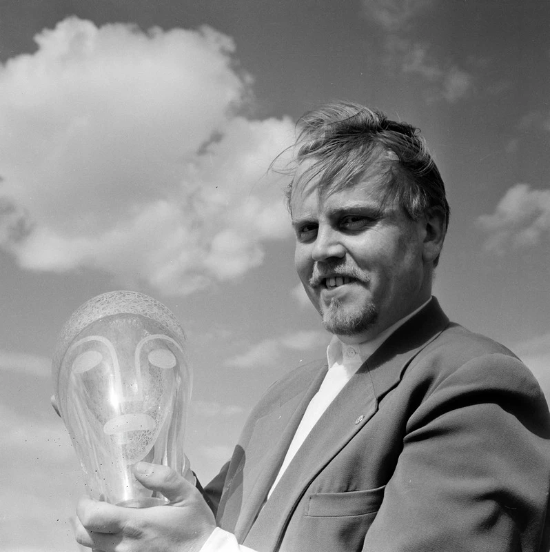 Svartvitt foto på man som håller ett glaskonstverk.