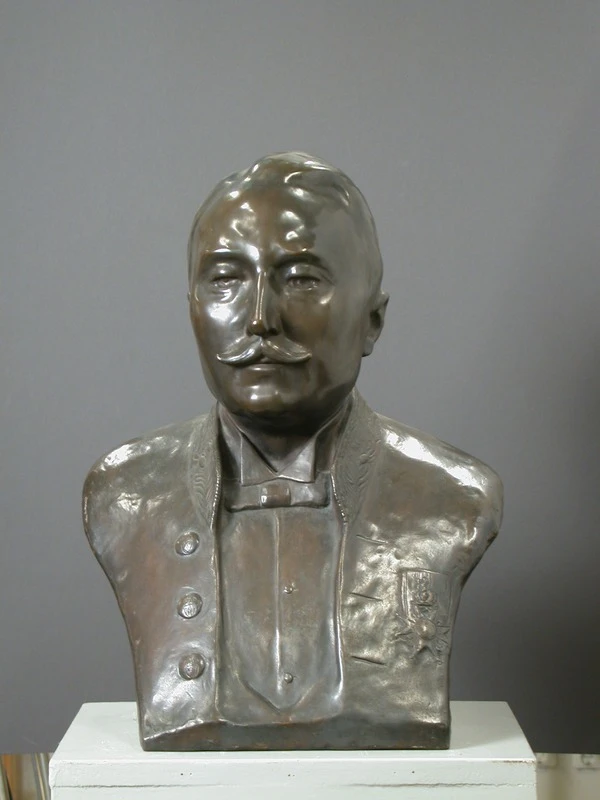 Foto av byst i brons förställande en man.