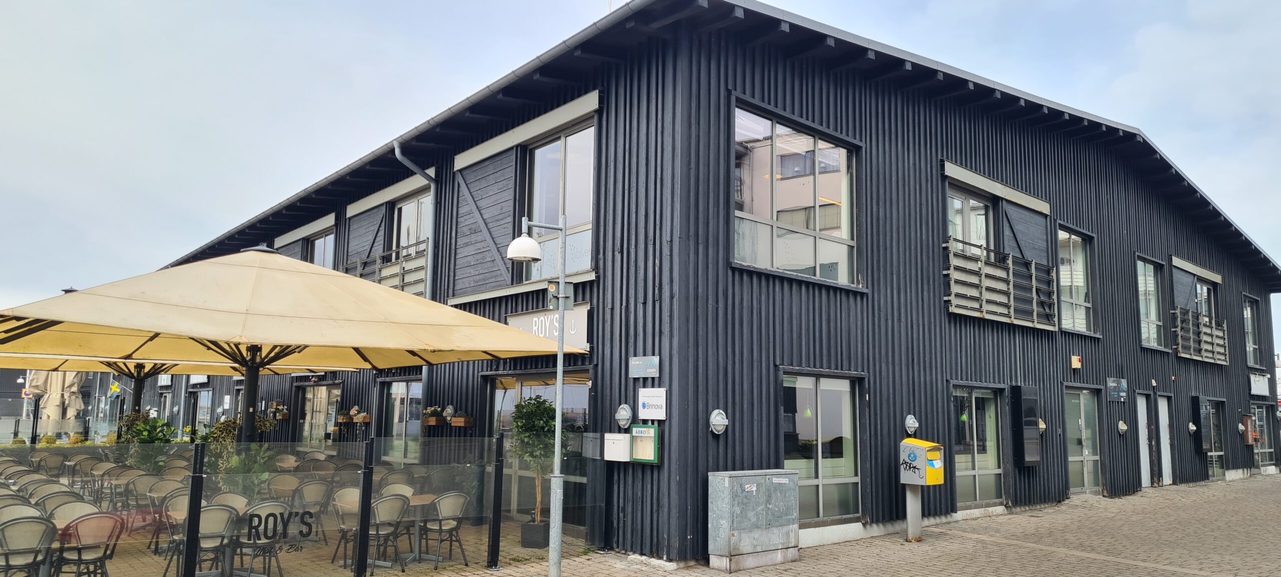 Svart byggnad med träpanel med servering i ena änden.