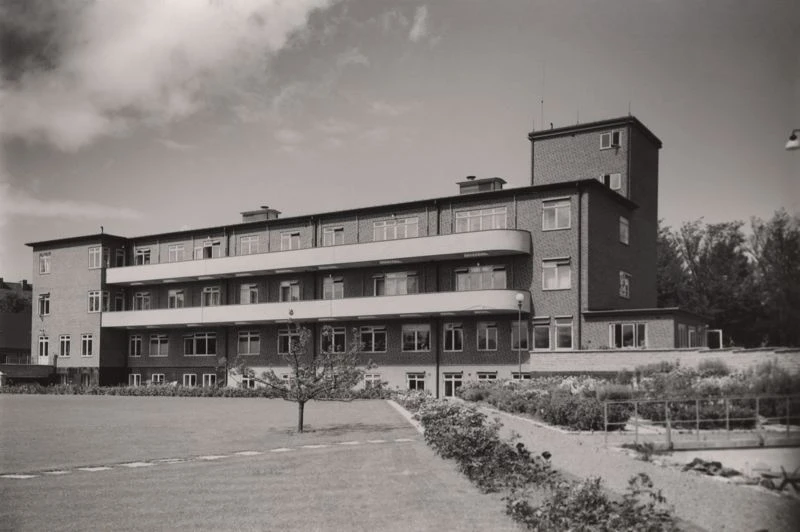 Svartvitt foto på långsträckt byggnad i funkisstil.