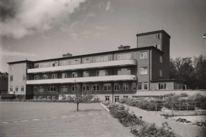 Svartvitt foto på långsträckt byggnad i funkisstil.