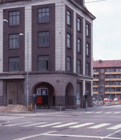 Fyravåningsbyggnad i brunt med ljusare hörntegel.