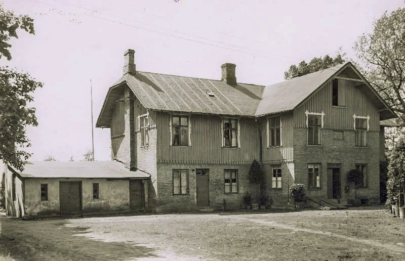 Svartvitt foto på trähus i två våningar. 