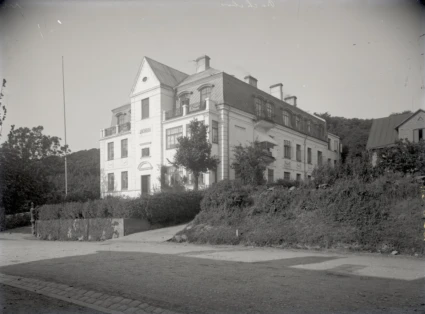 Svartvitt foto av trevåningsvilla i klassicistisk stil.