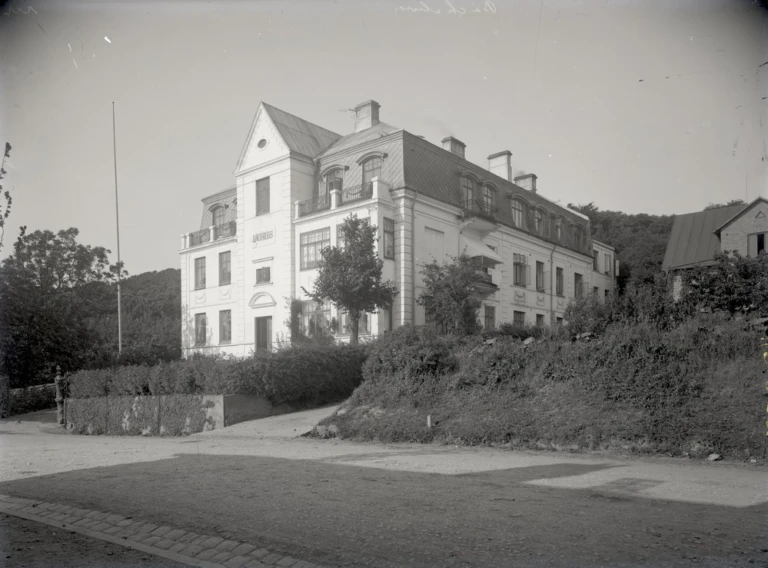 Svartvitt foto av trevåningsvilla i klassicistisk stil.