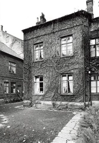 Svartvitt foto på tvåvåningsfastighet. 