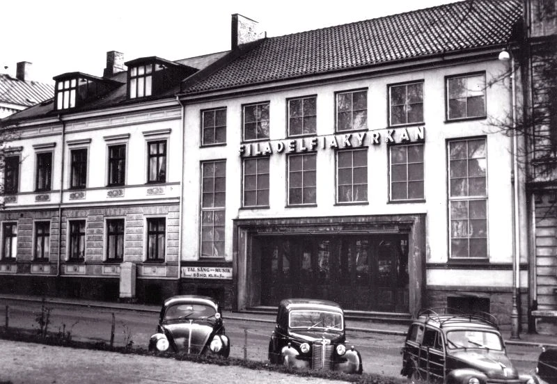 Svartvit bild med vitt hus och texten filadelfia på fasaden.