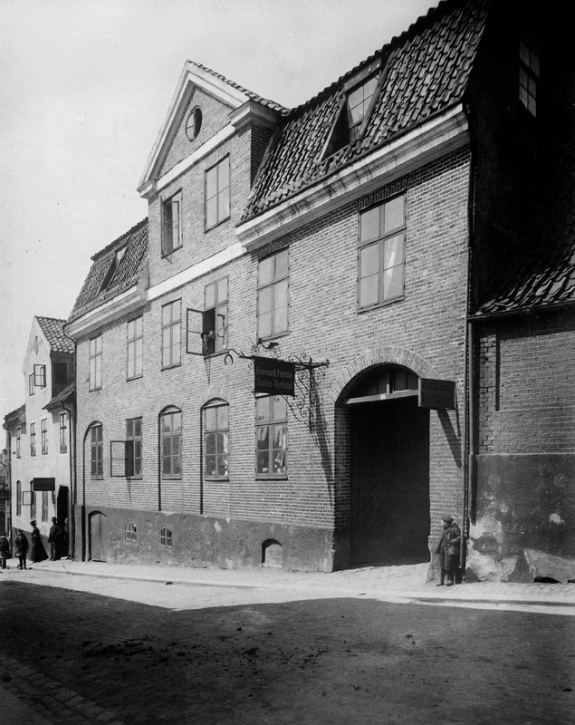 Svartvitt fotografi med en byggnad och verksamhetsskylt.