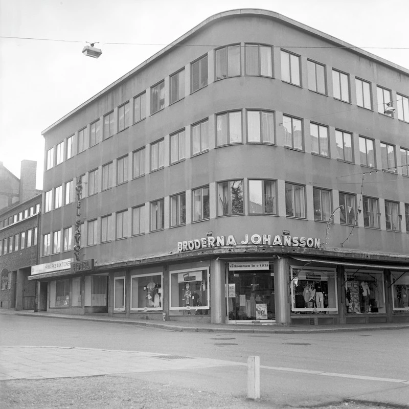 Svartvitt foto på husfasad med butik
