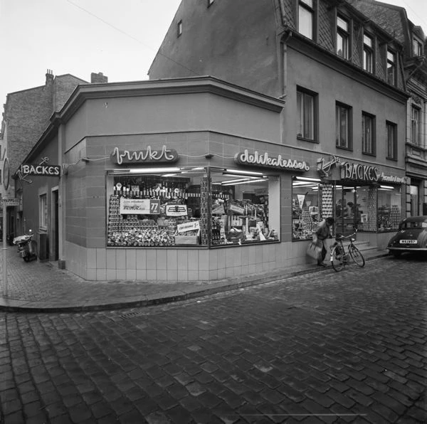 Svartvitt foto på butik i envåningshus.