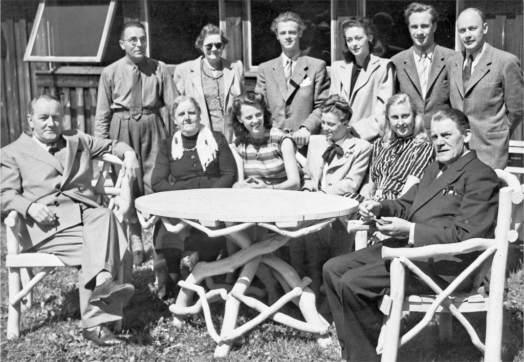 Teaterensemblen församlad vid teaterladan på Fredriksdal en sommardag under slutet av 1940-talet. Sittande till vänster Otto Landahl och på den högra stolen teaterdirektören Thure Carlman. Lindberg Foto, ur Björn Engdahls samling.