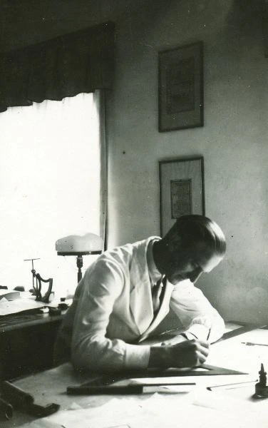 Acking som lutar sig över ett skrivbord.