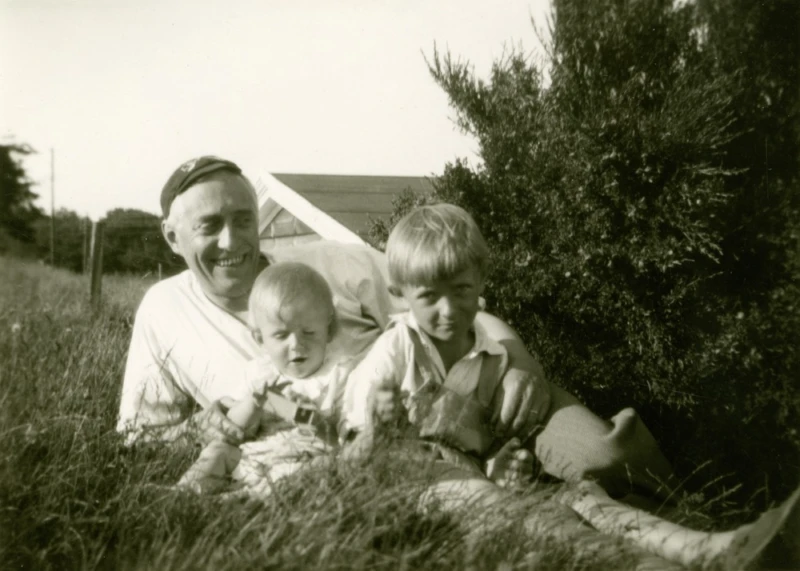 Svartvitt foto på äldre man med två barn. 