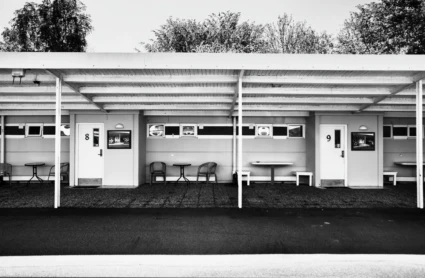 Svartvit bild med enplans motellrum.