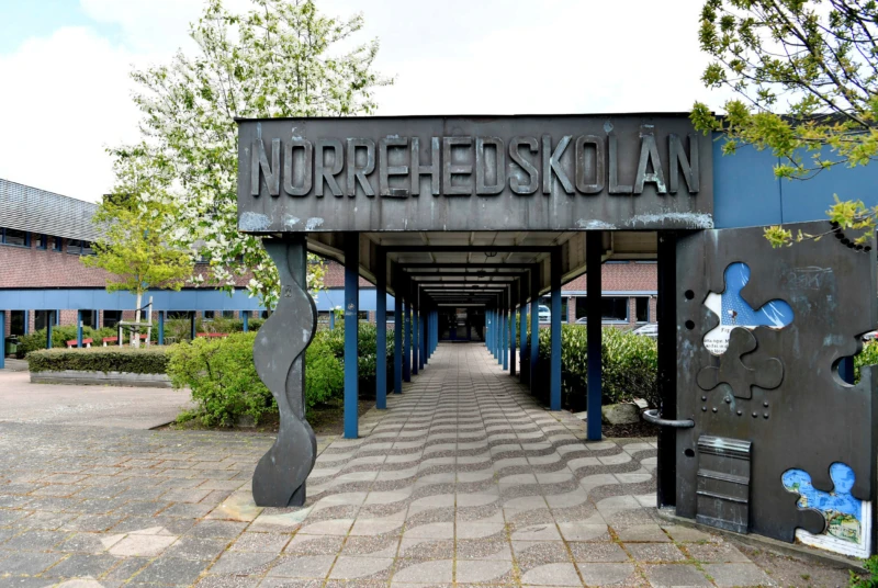 Exteriör med överbyggd gång in till byggnaden. 