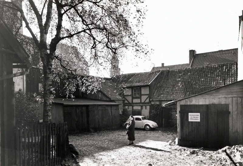 Béenska gården sedd från inkörsporten på Norra Storgatan 1962. Bostadshuset i vänsterkant i bilden och Rådhusets torn skymtar fram bakom trädet. Foto: Helsingborgs museum 62_256