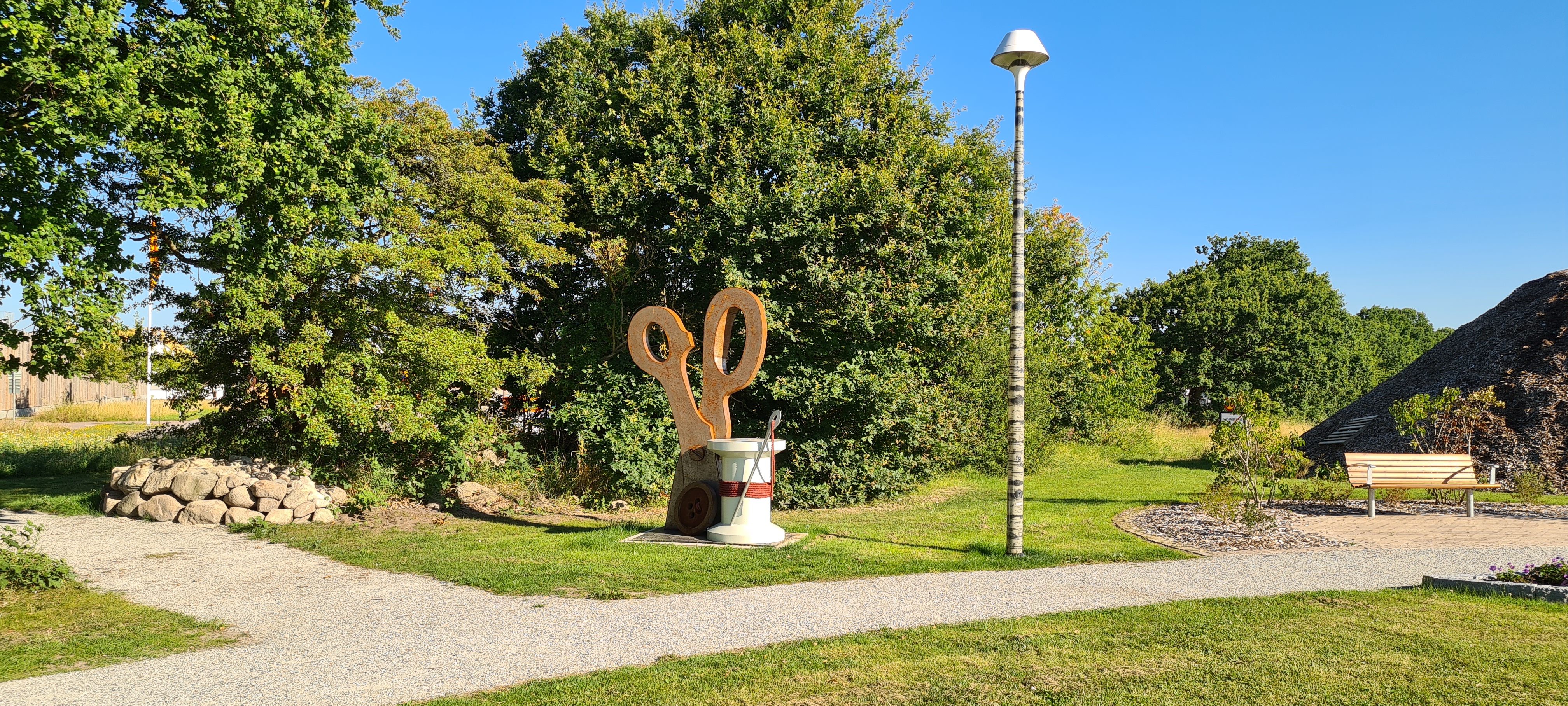 Skulptur i form av en jättestor sax och trådrulle. 