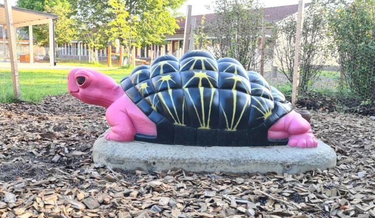 Skulptur av en ceriserosa sköldpadda.