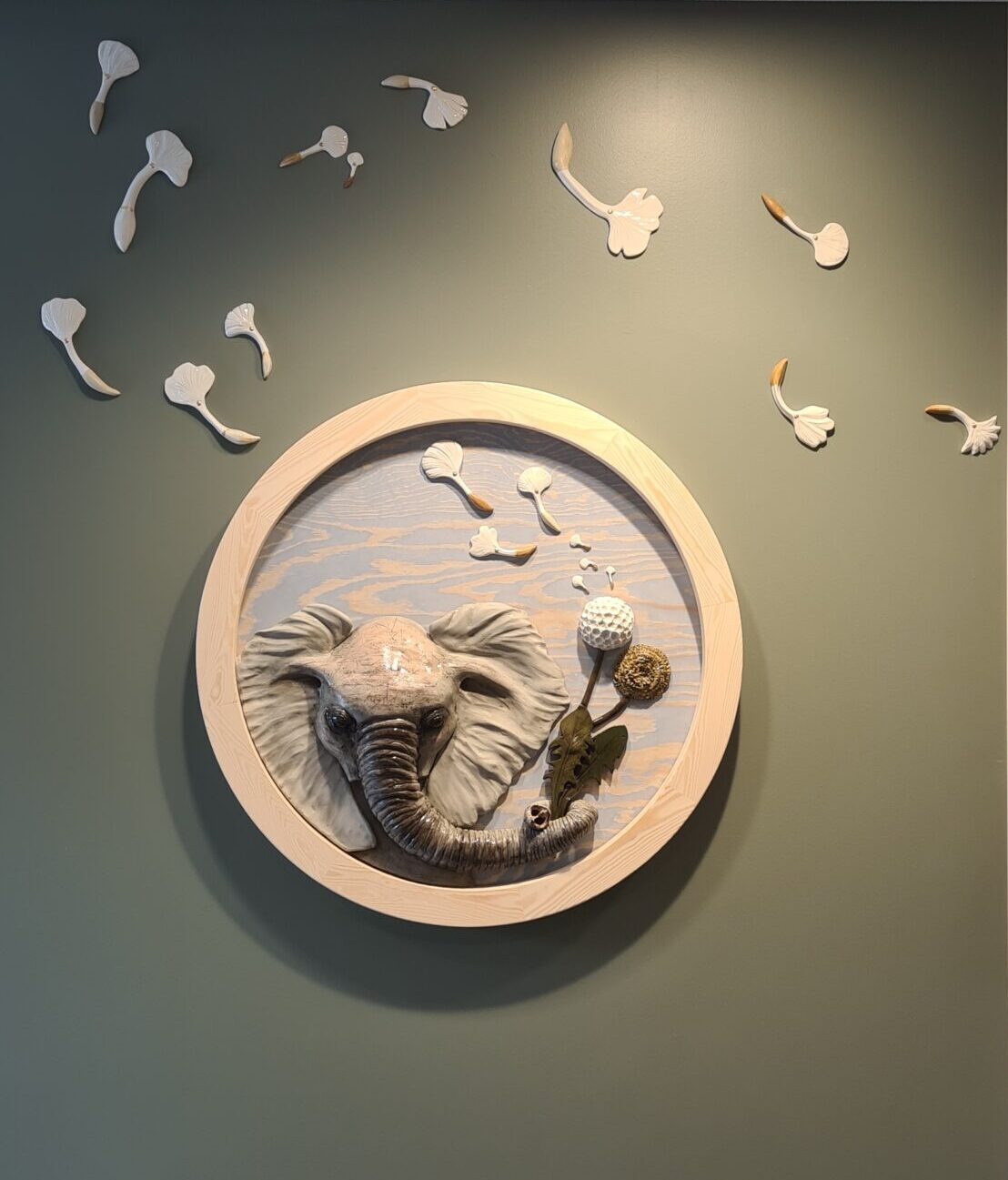 konstverk med elefant som blåser maskrosfrö