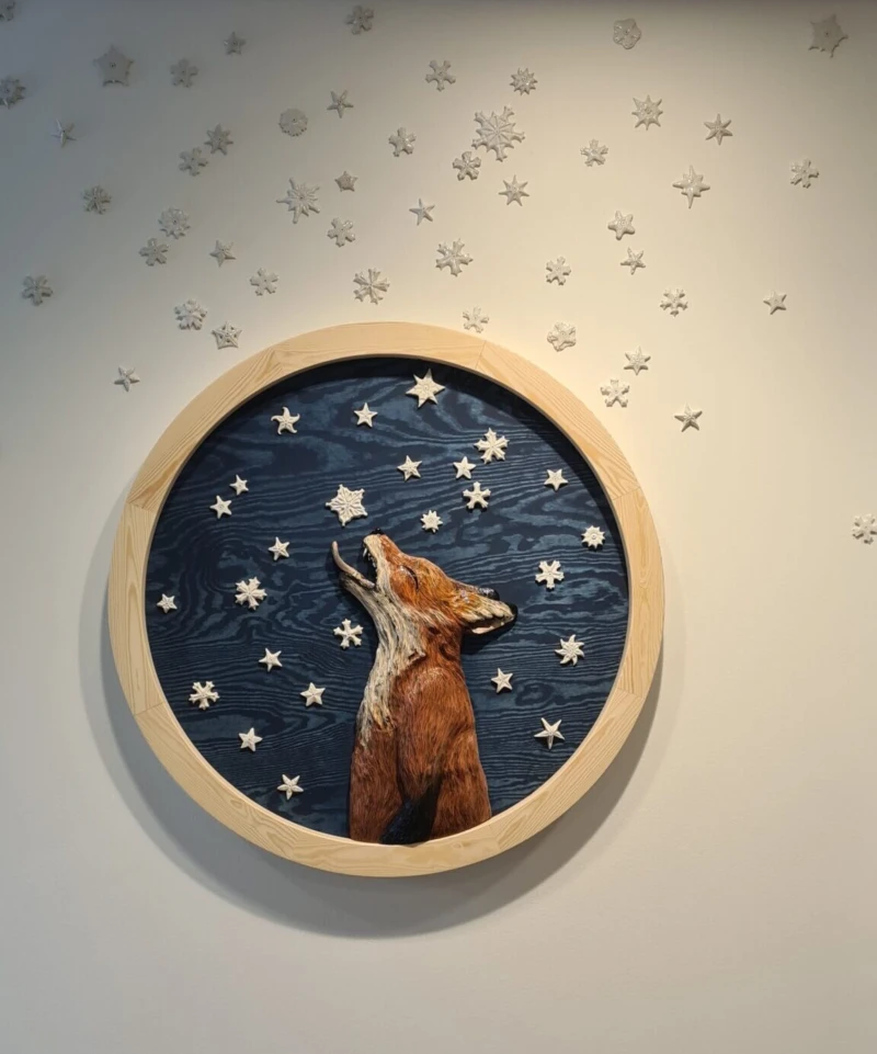 Konstverk med en räv som äter snö